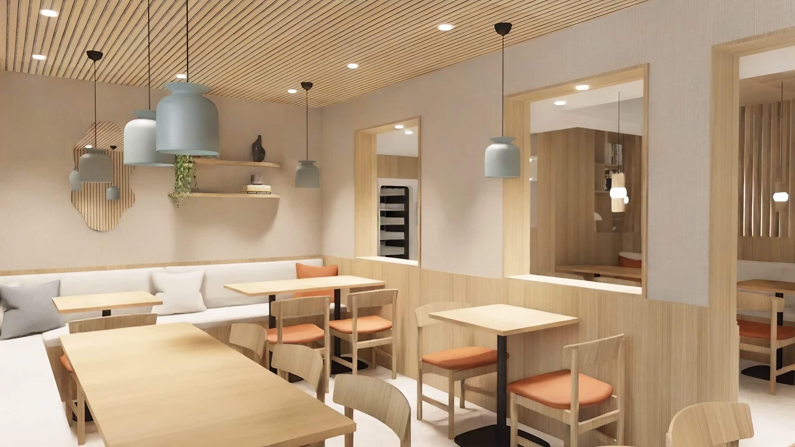 Essbereich mit hellen Holzmöbeln, hellblauen Pendelleuchten und indirekter Beleuchtung an den Wänden.