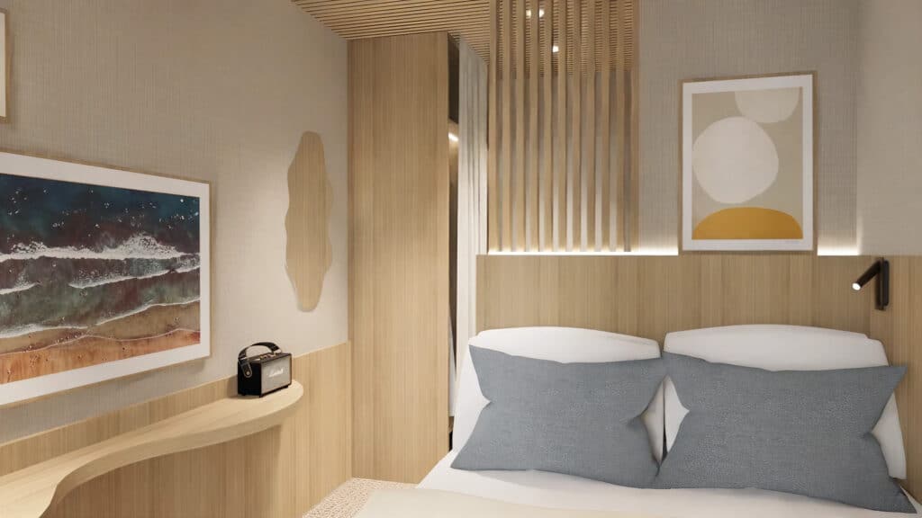 Kompaktes Hotelzimmer mit hellem Holz-Kopfteil, zwei grauen Kissen auf weißer Bettwäsche und einem organisch geformten Wandelement.