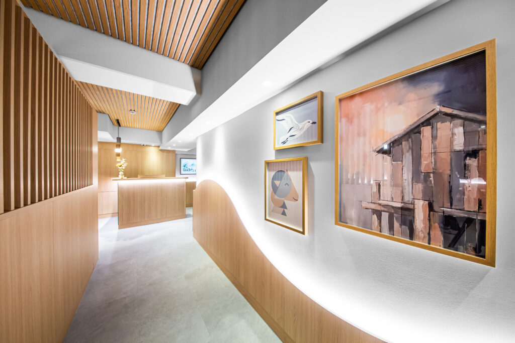 Moderner Hotelflur im Hotel Bude54 mit Kunstwerken an der Wand und indirekter Beleuchtung, die für nordische Klarheit sorgt.