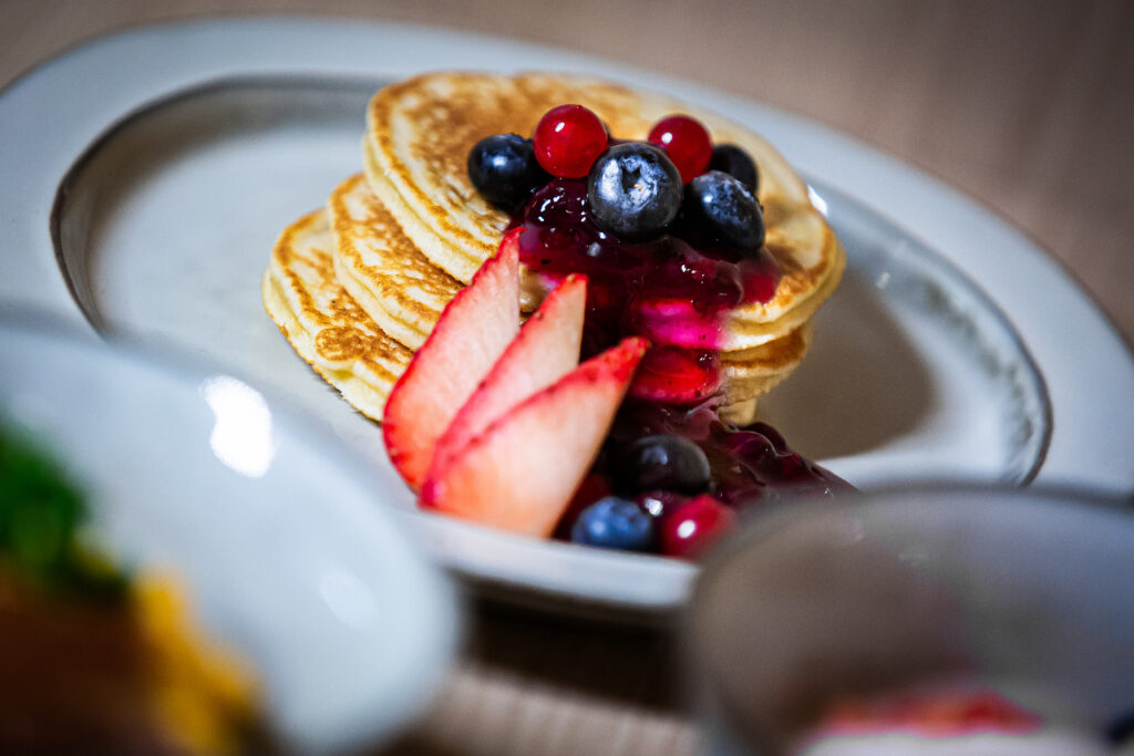 Teller mit Pancakes und Blaubeeren beim Frühstück im Hotel Bude54.